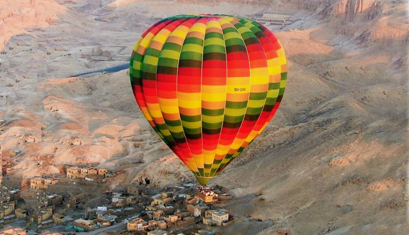 Image result for A hot air balloon carrying foreign tourists over Egypt’s ancient city